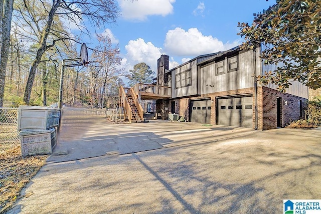 view of side of home featuring a garage and a deck