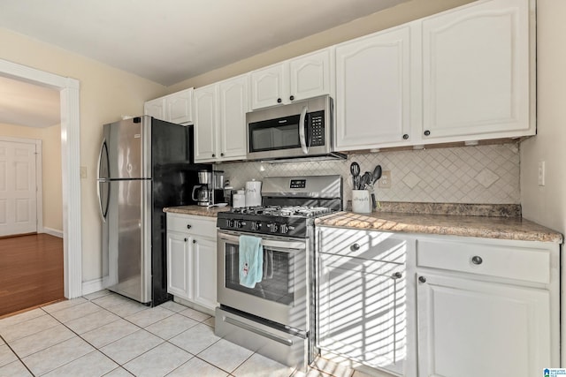 kitchen with white cabinetry, tasteful backsplash, stainless steel appliances, and light tile patterned flooring