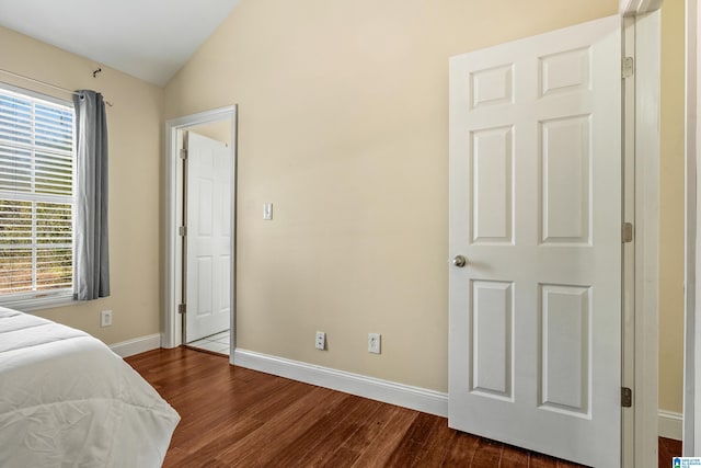 bedroom with lofted ceiling and dark hardwood / wood-style floors