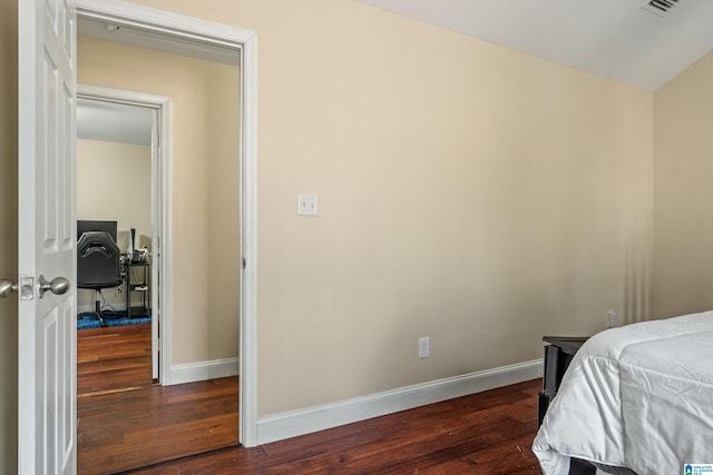 bedroom with dark hardwood / wood-style flooring