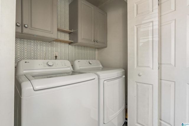 laundry area with cabinets and washing machine and clothes dryer