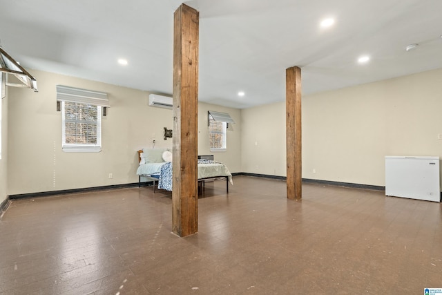 basement with a wall mounted air conditioner and fridge