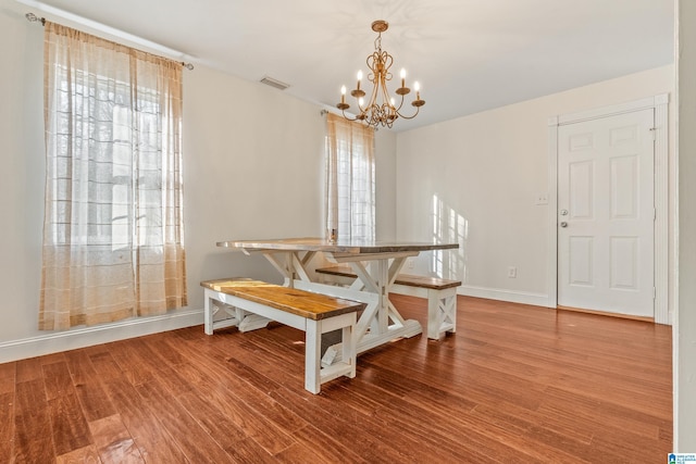 dining room with hardwood / wood-style flooring and a chandelier