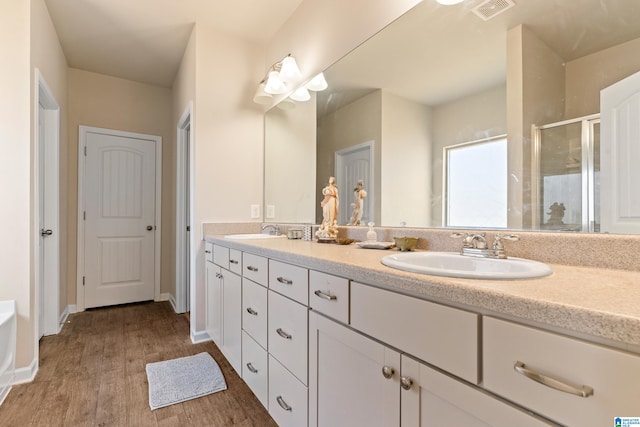 bathroom featuring vanity, wood-type flooring, and walk in shower