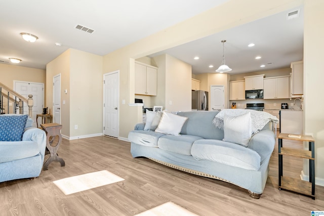 living room with sink and light wood-type flooring