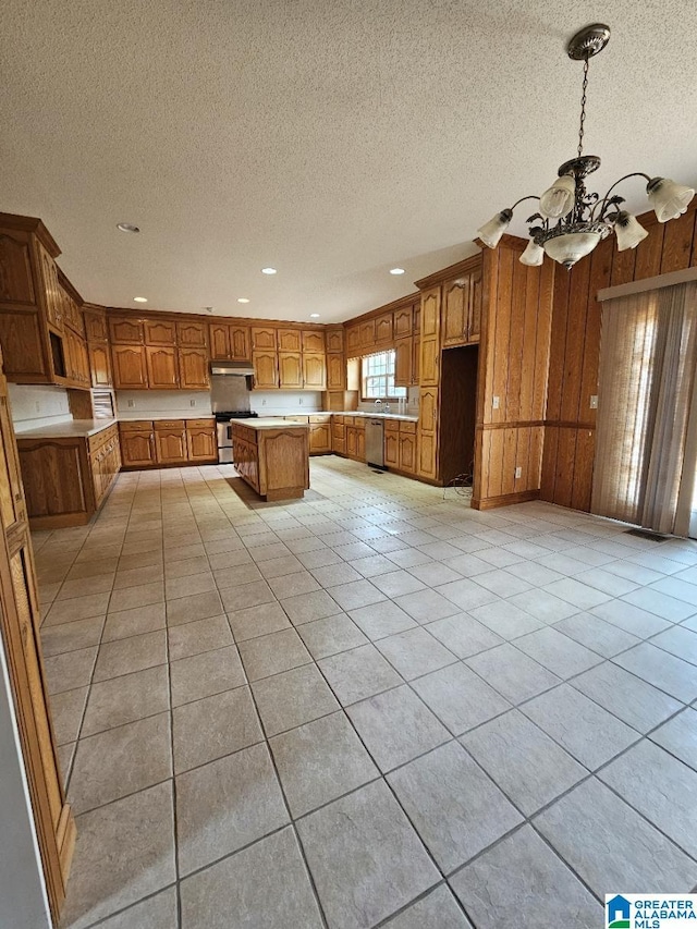 kitchen with light tile patterned floors, stainless steel appliances, a chandelier, and a kitchen island