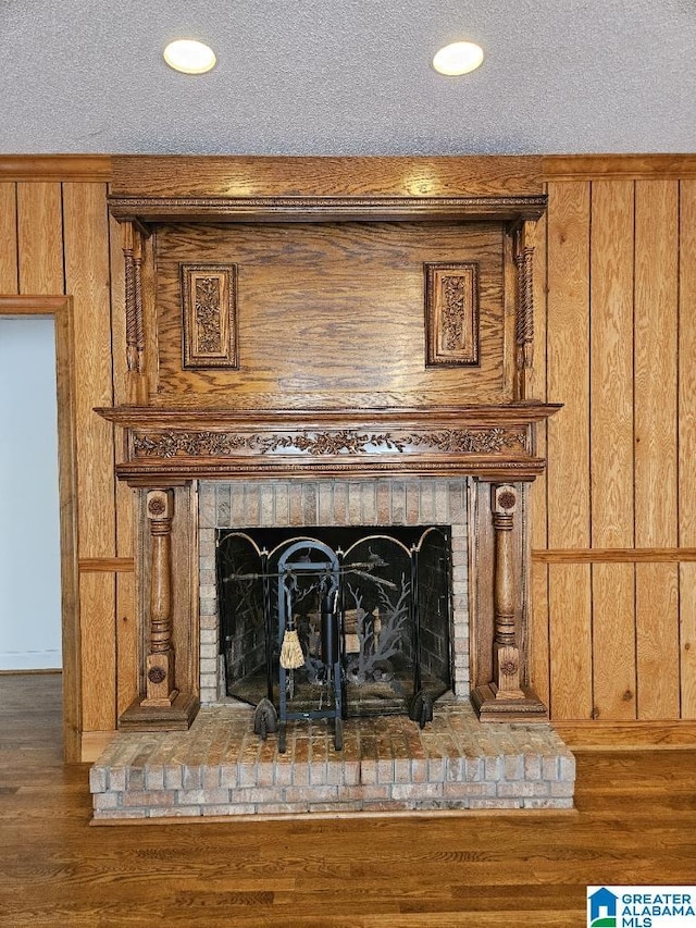 details featuring wood-type flooring, wooden walls, and a brick fireplace