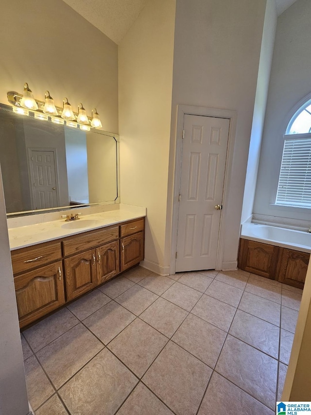 bathroom with vanity, high vaulted ceiling, tile patterned floors, and a tub