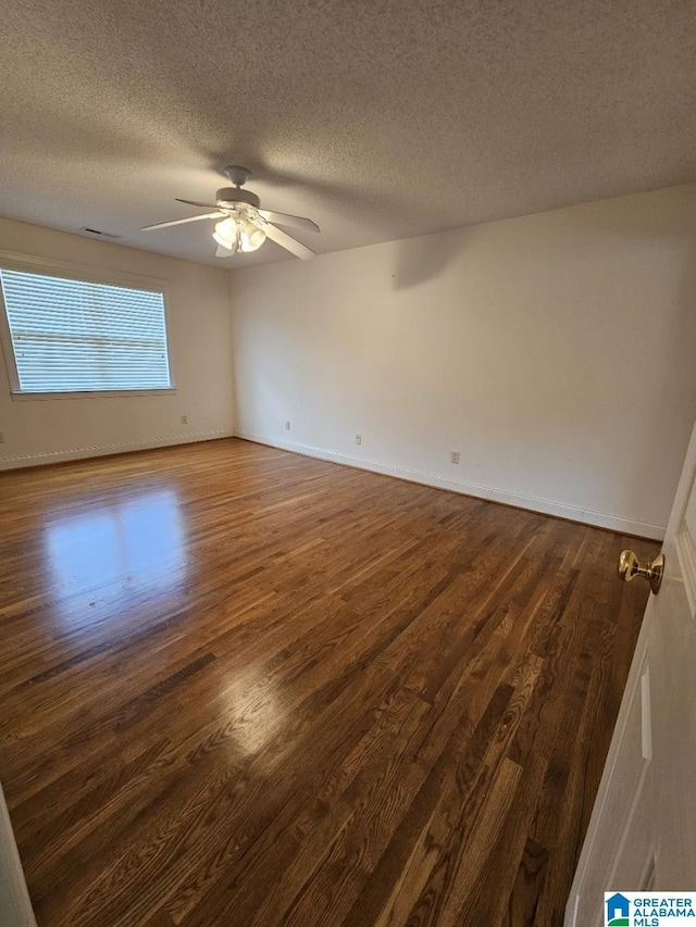 unfurnished room featuring ceiling fan, dark hardwood / wood-style floors, and a textured ceiling