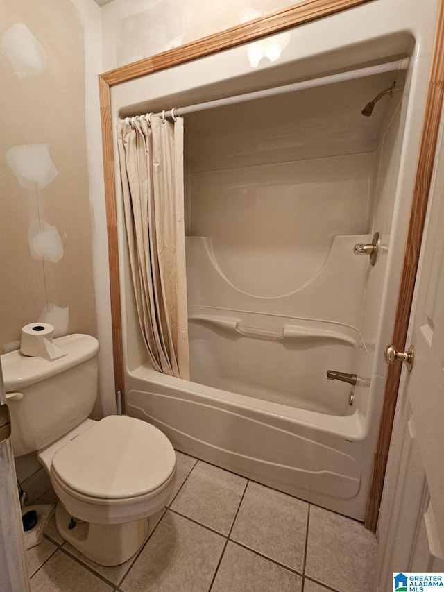 bathroom with tile patterned flooring, shower / tub combo, and toilet