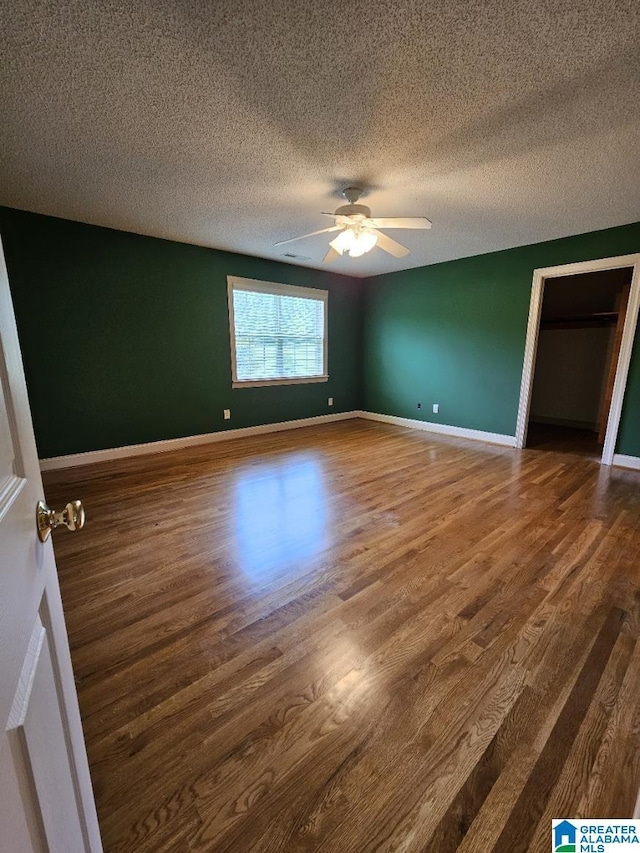 unfurnished bedroom with hardwood / wood-style flooring, a textured ceiling, and ceiling fan