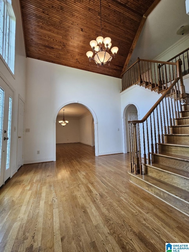 entryway featuring high vaulted ceiling, a notable chandelier, wooden ceiling, and light hardwood / wood-style floors