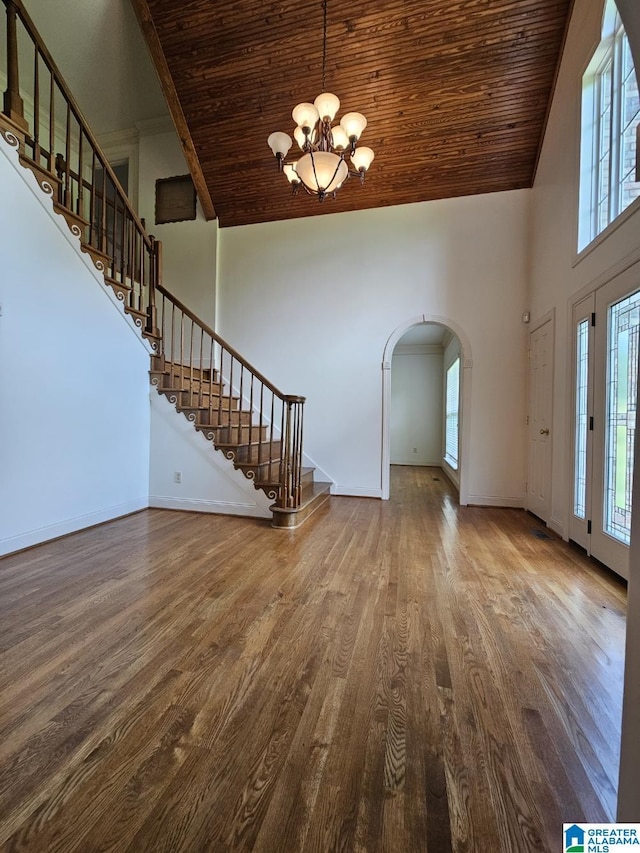 unfurnished living room with a notable chandelier, wood-type flooring, wooden ceiling, and high vaulted ceiling