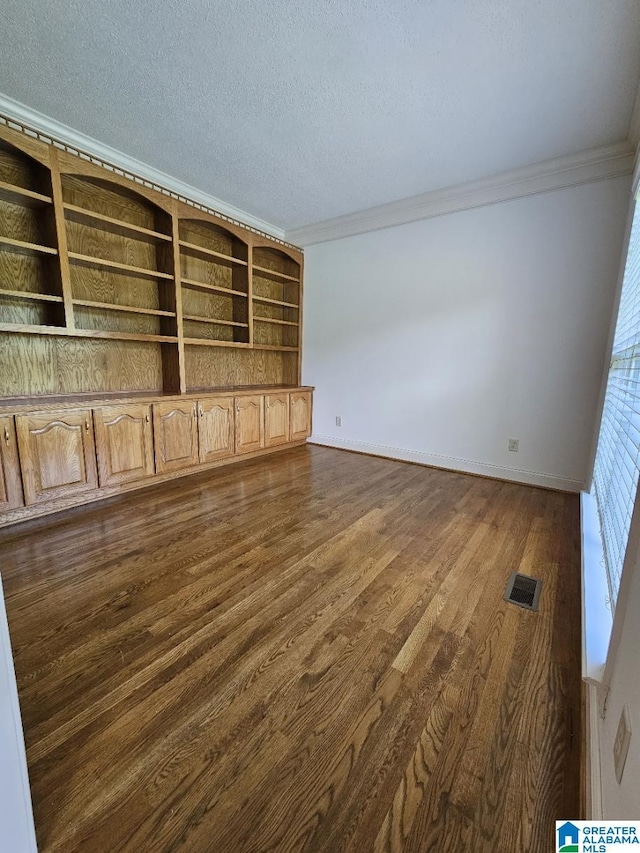 unfurnished living room featuring ornamental molding, dark hardwood / wood-style floors, built in features, and a textured ceiling