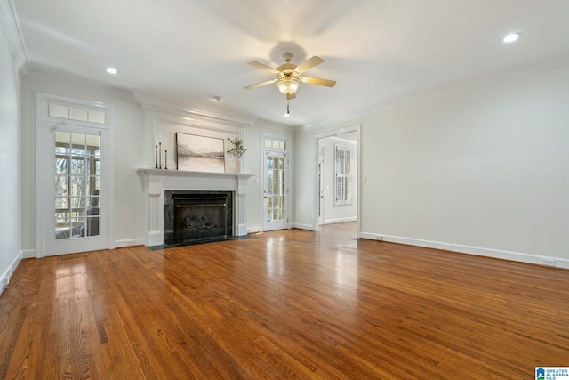 unfurnished living room with ceiling fan, ornamental molding, and wood-type flooring