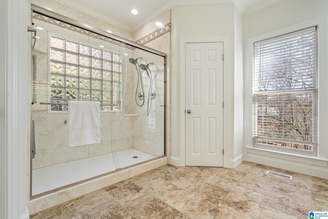 bathroom featuring a shower with door and crown molding