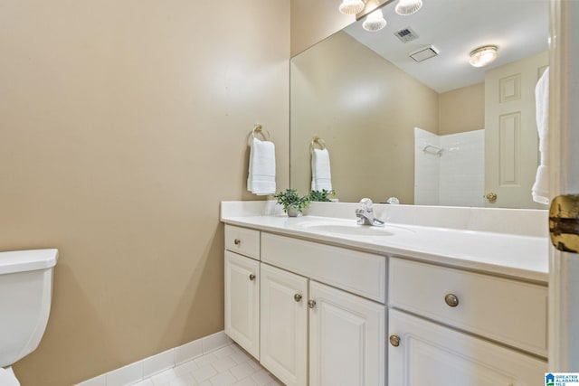 bathroom with tile patterned flooring, vanity, a shower, and toilet