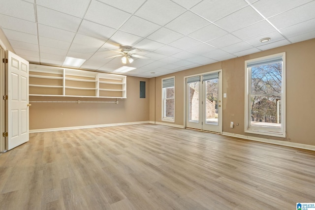 unfurnished living room with ceiling fan, light hardwood / wood-style floors, and a drop ceiling