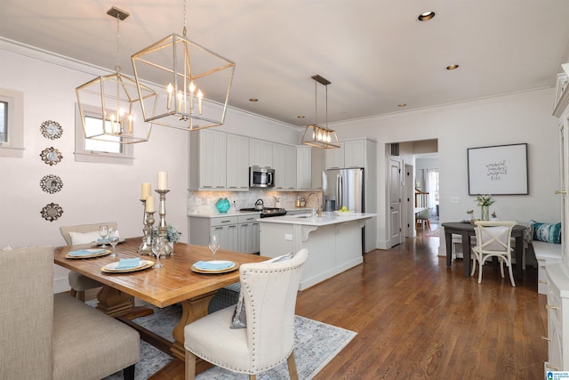 dining space featuring dark hardwood / wood-style flooring, sink, and ornamental molding