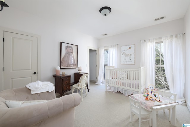 carpeted bedroom featuring a crib