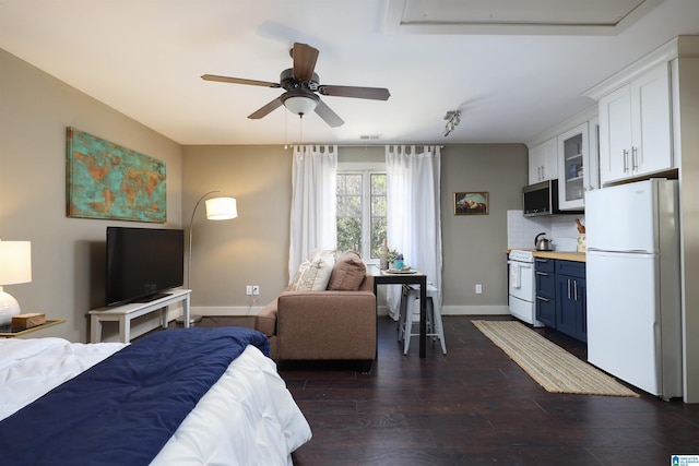 bedroom with dark hardwood / wood-style flooring, ceiling fan, and white refrigerator