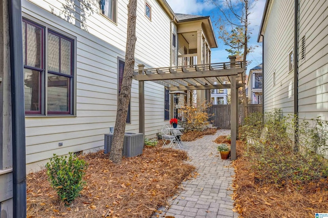 view of property exterior featuring cooling unit and a pergola