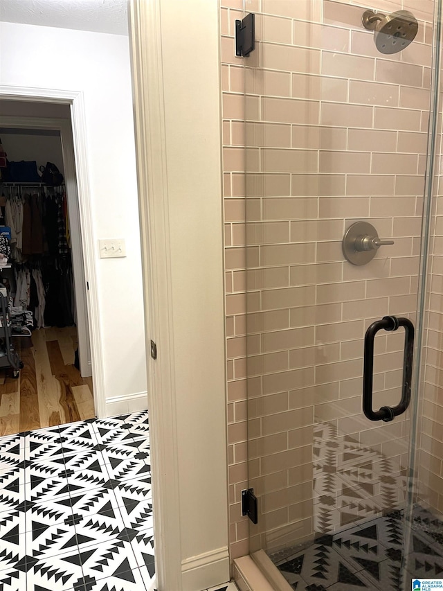 bathroom featuring wood-type flooring and a shower with door