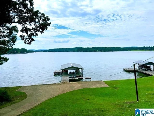 view of dock with a water view and a lawn