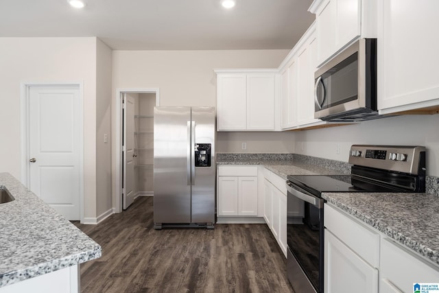 kitchen featuring white cabinetry, light stone countertops, dark hardwood / wood-style floors, and appliances with stainless steel finishes