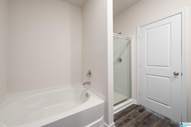 bathroom featuring hardwood / wood-style flooring and plus walk in shower