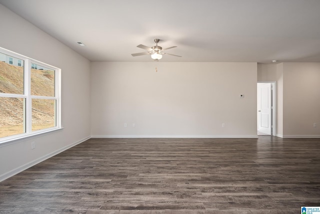 spare room with dark wood-type flooring and ceiling fan