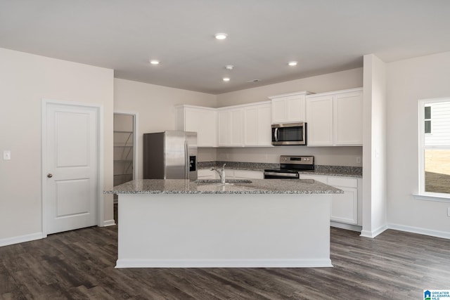 kitchen featuring appliances with stainless steel finishes, dark hardwood / wood-style floors, an island with sink, sink, and white cabinets