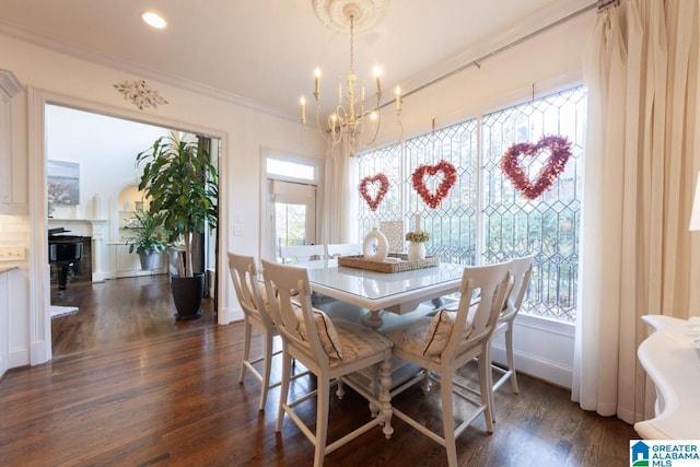 dining space with crown molding, plenty of natural light, an inviting chandelier, and dark hardwood / wood-style flooring