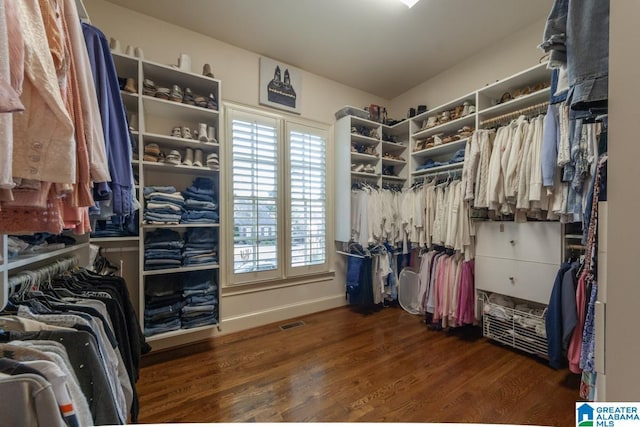 spacious closet with dark hardwood / wood-style flooring