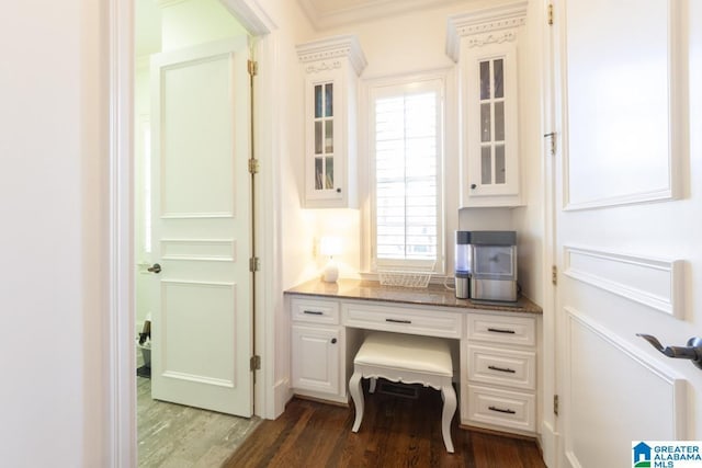 office area with dark wood-type flooring and ornamental molding