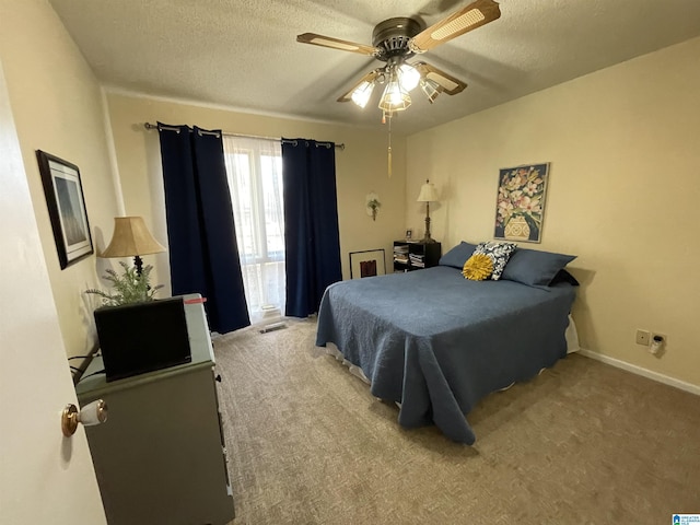 carpeted bedroom featuring a textured ceiling and ceiling fan