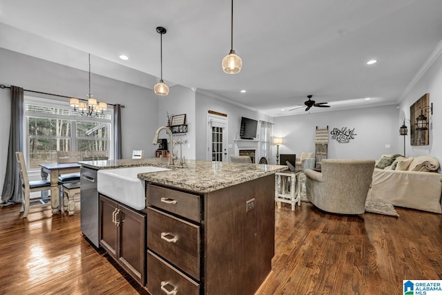 kitchen featuring dishwasher, sink, hanging light fixtures, and a center island with sink