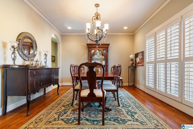 dining space with an inviting chandelier, ornamental molding, and dark hardwood / wood-style floors