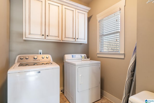 laundry room with washing machine and dryer and cabinets