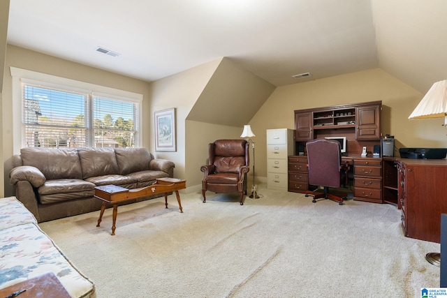 office area with vaulted ceiling and light colored carpet