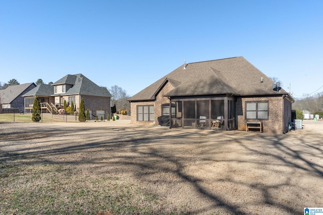 rear view of property featuring a sunroom