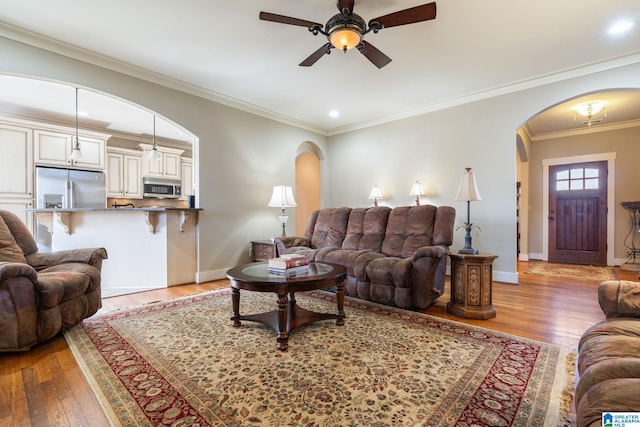 living room featuring crown molding, ceiling fan, and wood-type flooring