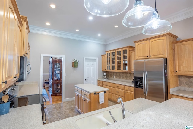 kitchen with tasteful backsplash, appliances with stainless steel finishes, sink, and a kitchen island