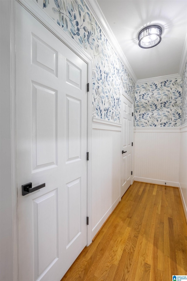 corridor featuring ornamental molding and light hardwood / wood-style floors