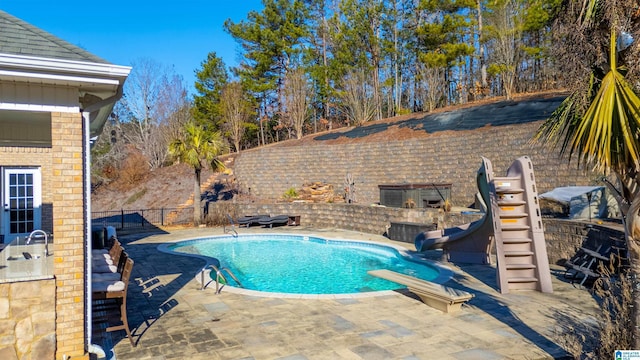 view of pool with a diving board and a patio area