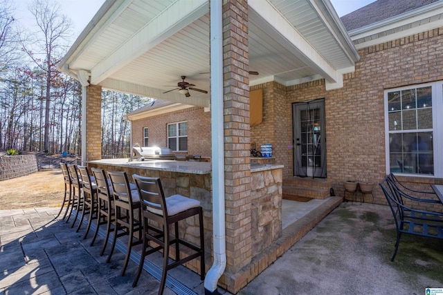 view of patio with a bar, ceiling fan, and area for grilling