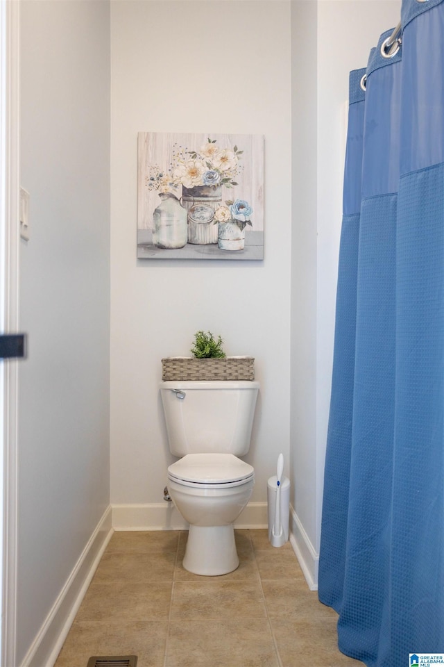 bathroom featuring walk in shower, toilet, and tile patterned flooring