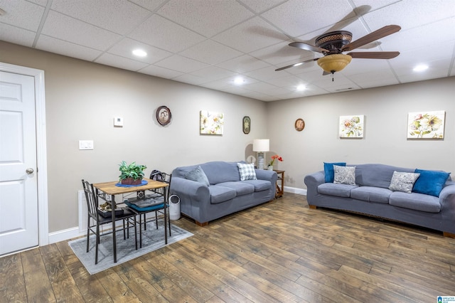 living room featuring ceiling fan, dark hardwood / wood-style flooring, and a paneled ceiling