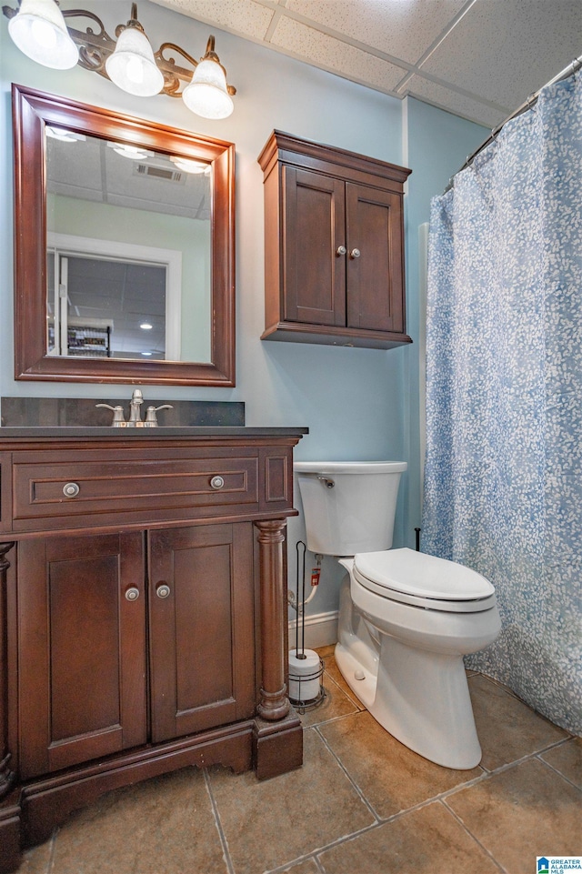 bathroom featuring vanity, a paneled ceiling, tile patterned floors, and toilet