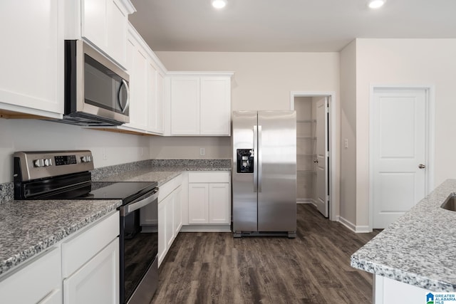 kitchen featuring light stone countertops, appliances with stainless steel finishes, dark hardwood / wood-style floors, and white cabinets